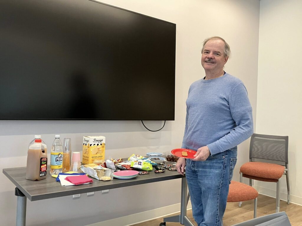 member posing at snack table