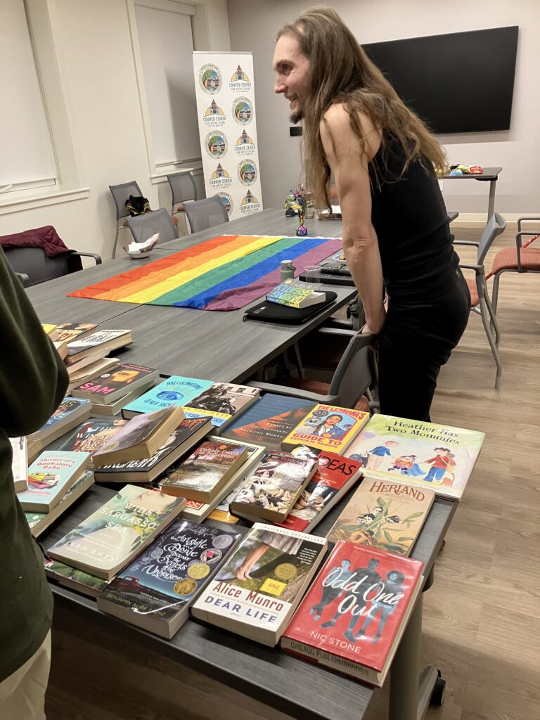 LGBTQ+ Newton member browsing books at the book swap