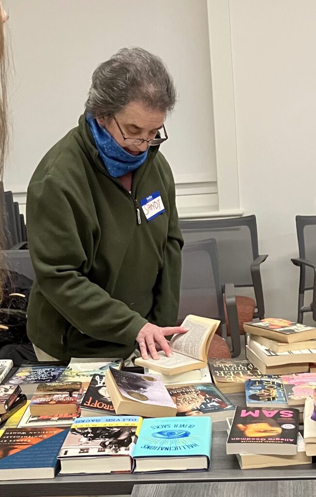 LGBTQ+ Newton member browsing books at the book swap