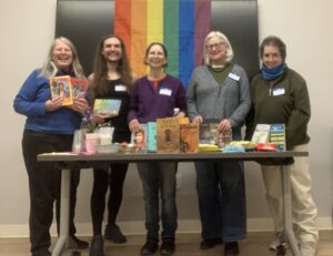 LGBTQ+ Newton members posing with the books at the book swap