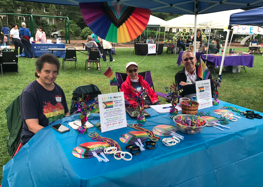 LGBTQ+ Newton members sitting behind a table at a Pride event