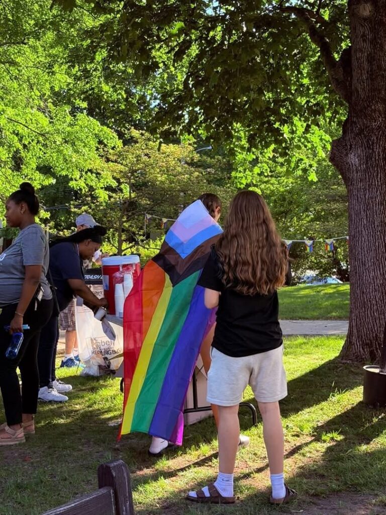 person wearing a pride flag as a cape